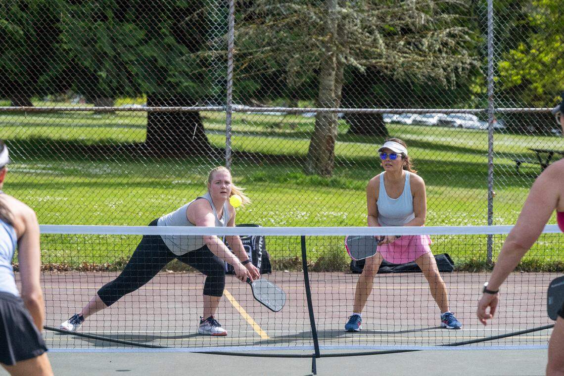 Brooke Berry, center left, reaches to return the ball in a game of pickleball with fellow Tacoma residents Christy Burdyshaw, center right, on Tuesday, May 6, 2025, at Point Defiance Park in Tacoma, Wash.
