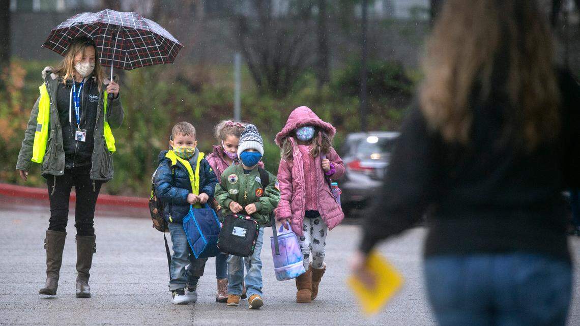 Kindergarten and first-grade students arrive for the first day of modified in-person learning at Sunrise Elementary School in Puyallup on Tuesday, Jan. 12, 2021.