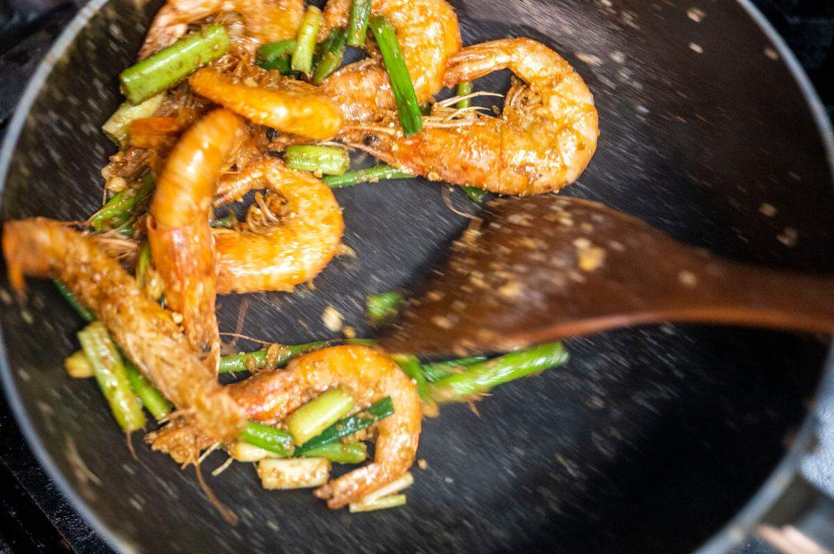 Du Dang, co-owner of Lunar’s Pho in Tacoma, stir-fries whole shrimp, basted in a sauce of salted duck eggs mashed with sugar, spices, garlic and scallions. The dish is packed with umami.