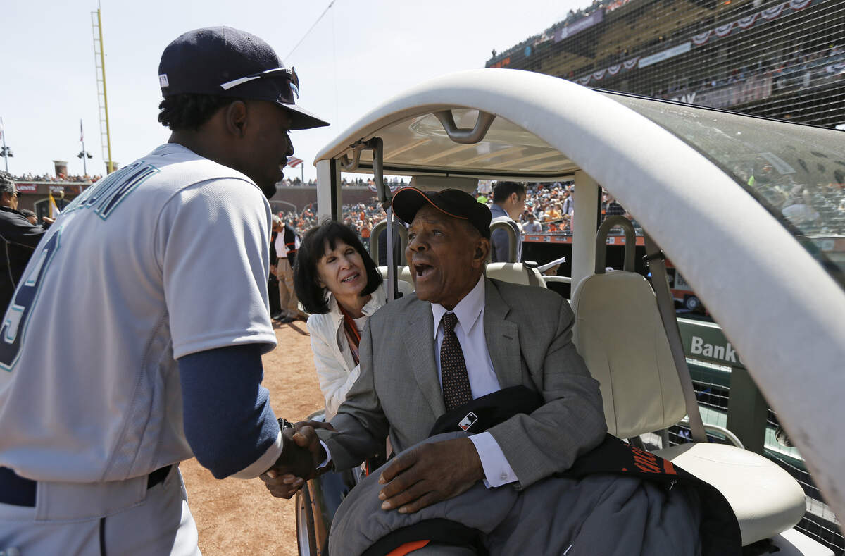 Seattle Mariners' Dee Gordon, left, greets Hall of Famer Willie Mays before the start of an opening day baseball game between the San Francisco Giants and the Mariners Tuesday, April 3, 2018, in San Francisco. (AP Photo/Eric Risberg)