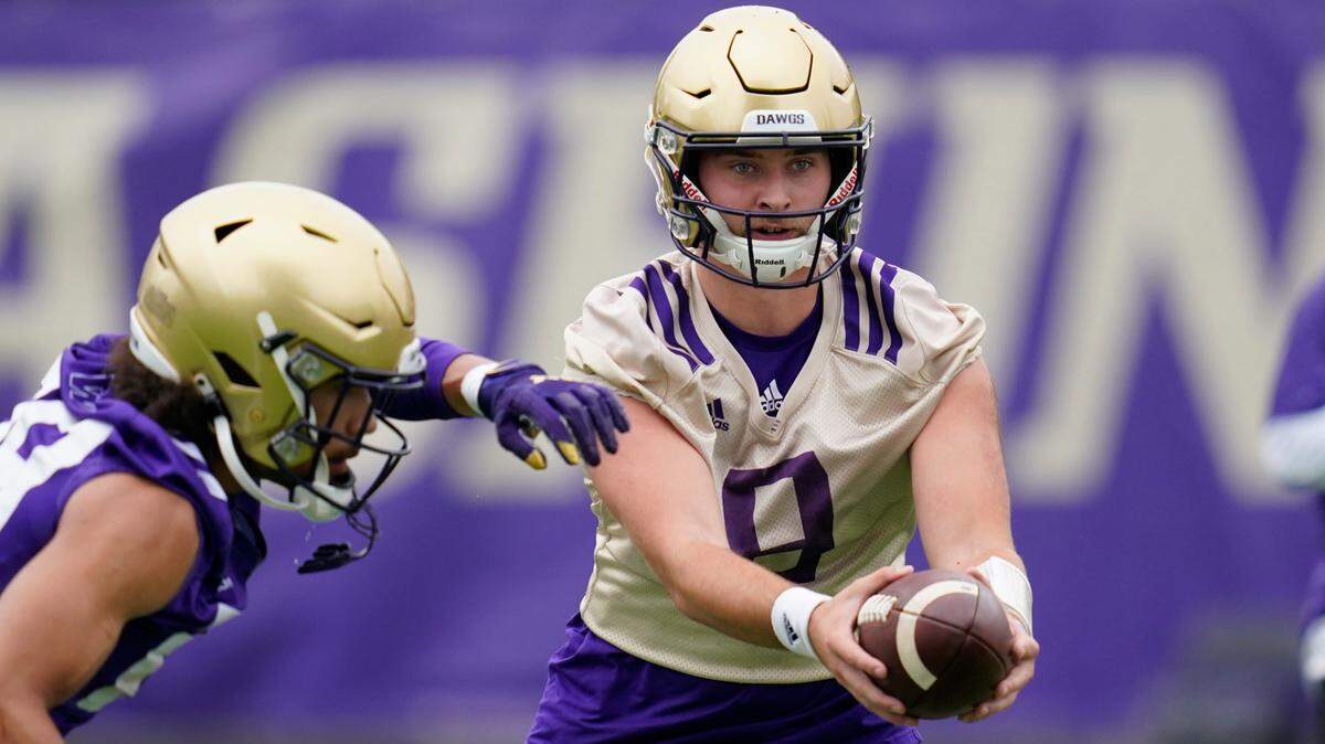 Washington Huskies quarterback Dylan Morris hands-off the ball during an NCAA college football team practice Friday, Aug. 6, 2021, in Seattle. (AP Photo/Elaine Thompson)