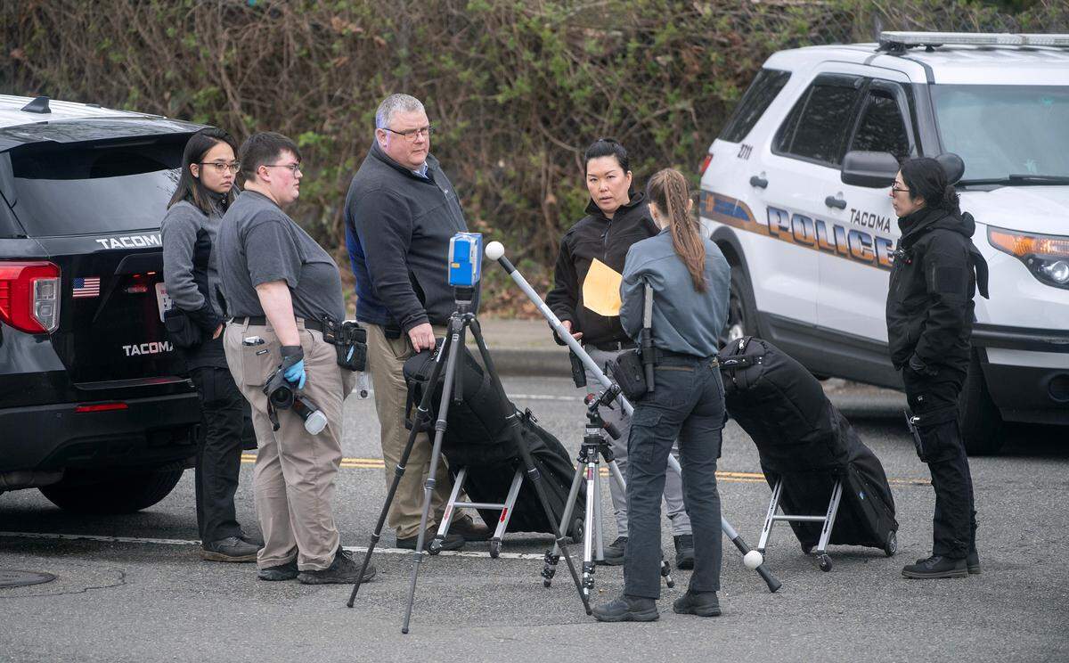 Tacoma police investigators gather on Tacoma Avenue South after a 38-year-old woman died of homicide on Wednesday, March 27, 2024, in Tacoma, Washington.