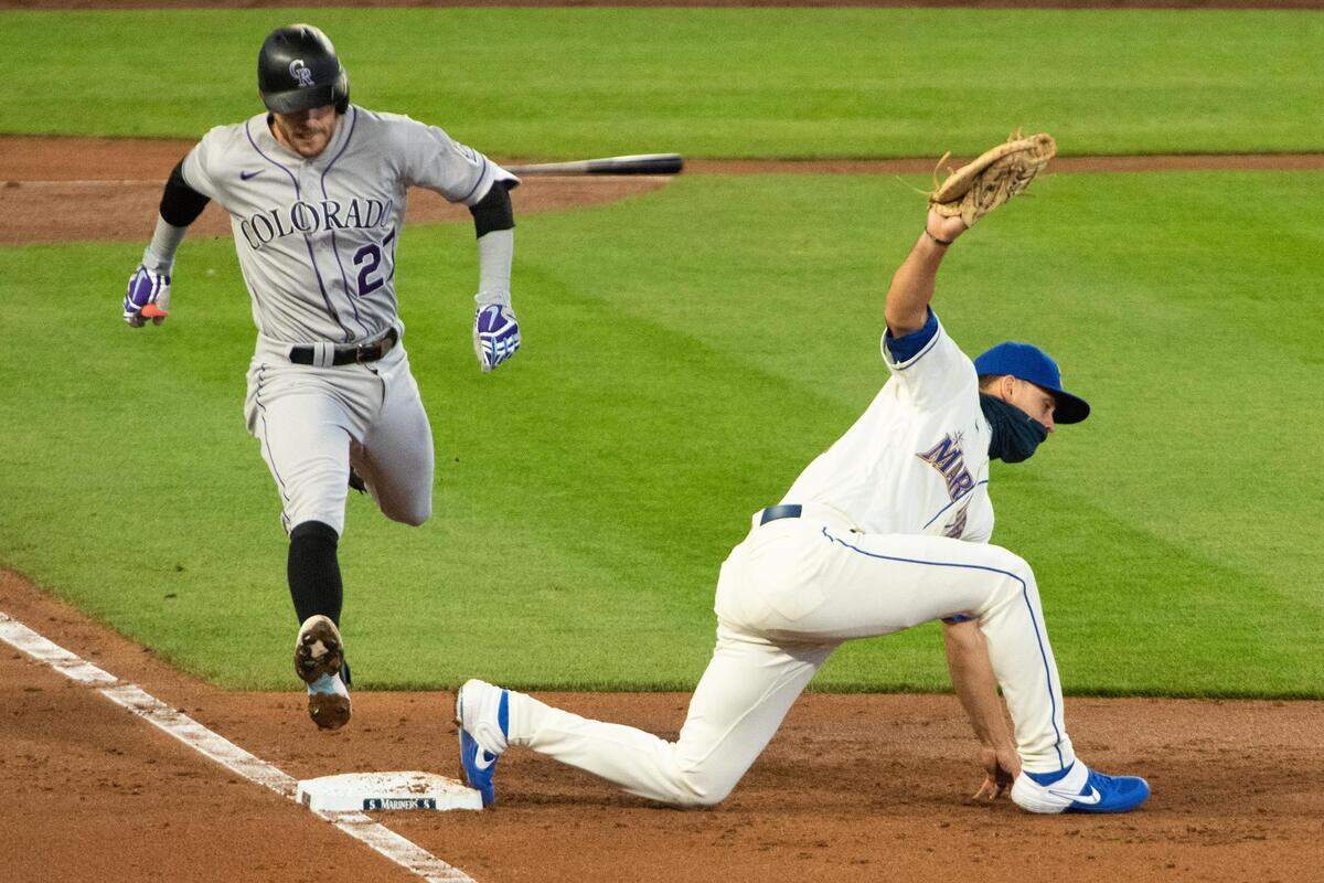 Seattle Mariners first baseman Evan White (12) digs a low throw out of the dirt to get out Colorado Rockies shortstop Trevor Story (27). The Seattle Mariners played the Colorado Rockies in a Major League Baseball game at T-Mobile Park in Seattle, Wash., on Sunday, Aug. 9, 2020.