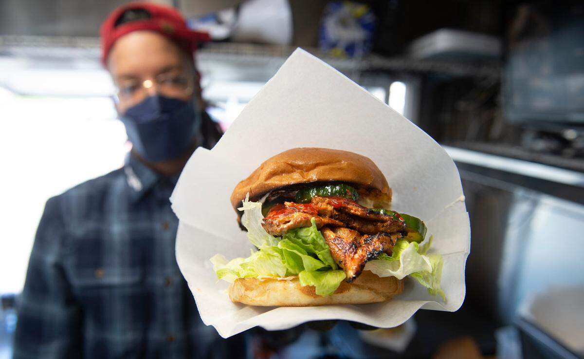 One of La’s longtime employees shows off the Fire Soul at the truck outside the 19th Street convenience store in March 2021.