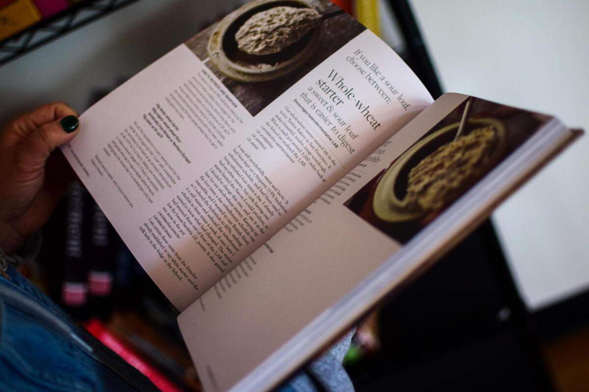 Leanne Franetovich leafs through the baking cookbook that inspired her to pursue breadmaking: The Sourdough School by Vanessa Kimbell. Co-owner of The Mill by Jack + Adeline, she wanted to offer the tools and ingredients to cook great meals at home.