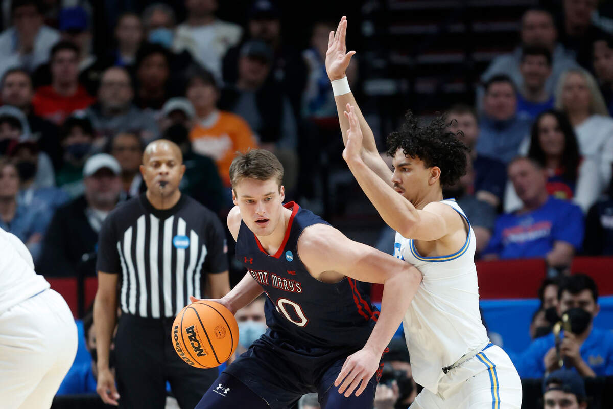 St. Mary’s center Mitchell Saxen, left, drives around UCLA guard Jules Bernard, right, during the first half of a second-round NCAA college basketball tournament game, Saturday, March 19, 2022, in Portland, Ore. (AP Photo/Craig Mitchelldyer)