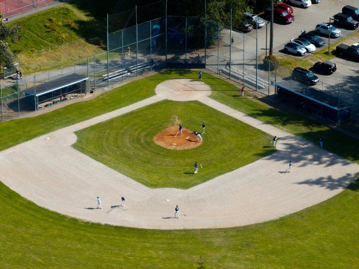 The Junior varsity baseball team cares for the baseball field at Gig Harbor High School, on Wednesday, April 30, 2025, in Gig Harbor.