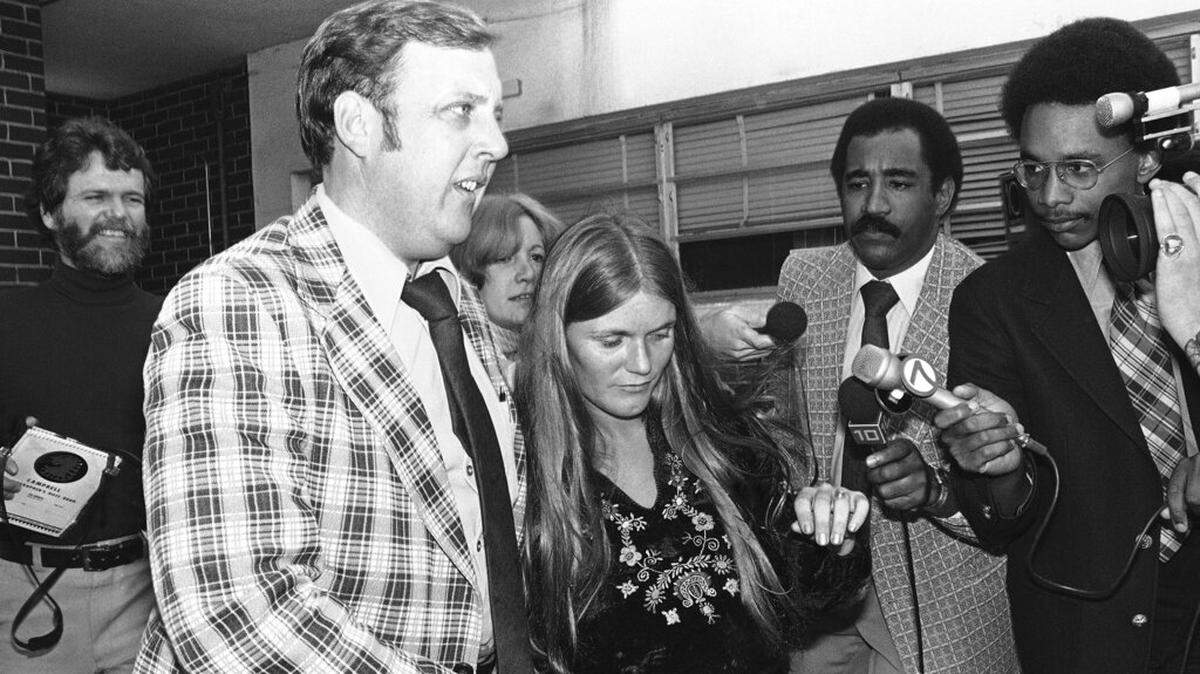 Linda Kasabian, center, leaves jail in the custody of authorities after being extradited to California as a material witness in the retrial of another former Charles Manson cultist, Tuesday, Jan. 5, 1977, Miami, Fla. Kasabian provided 18 straight days of testimony in the 1969 Tate-LaBianca murder trial.