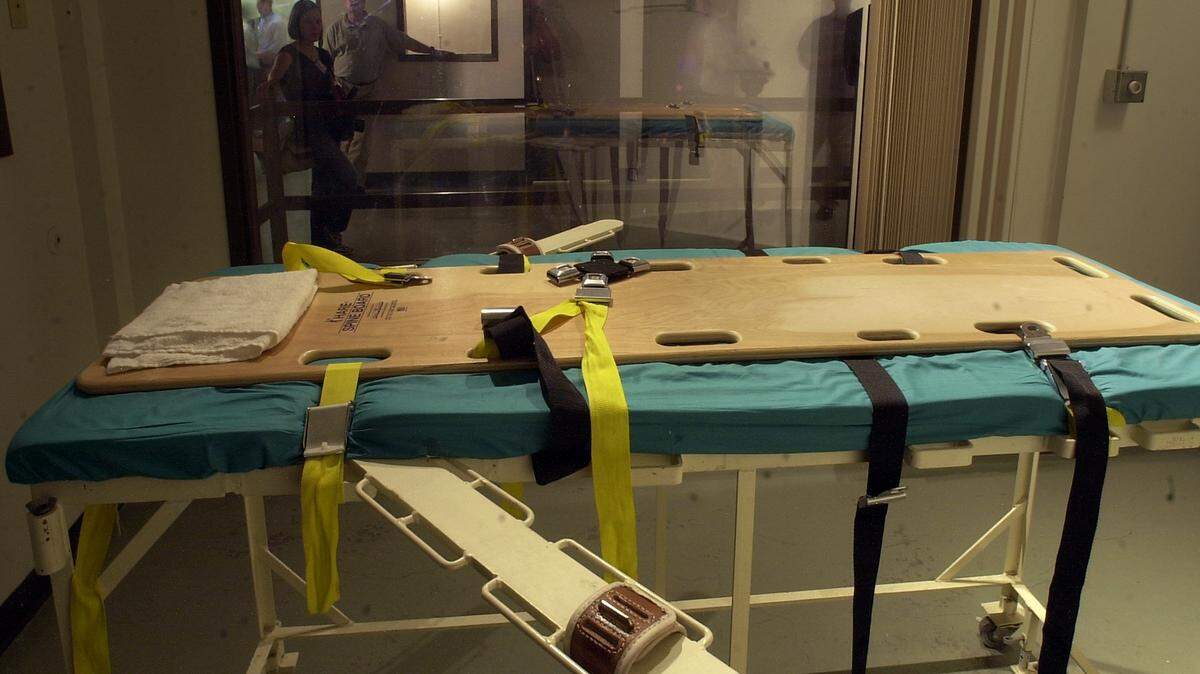 Members of the news media look through a large window into the execution chamber during a tour at the Washington State Penitentiary in Walla Walla, Washington on August 1, 2001. (Bruce Kellman/The News Tribune)