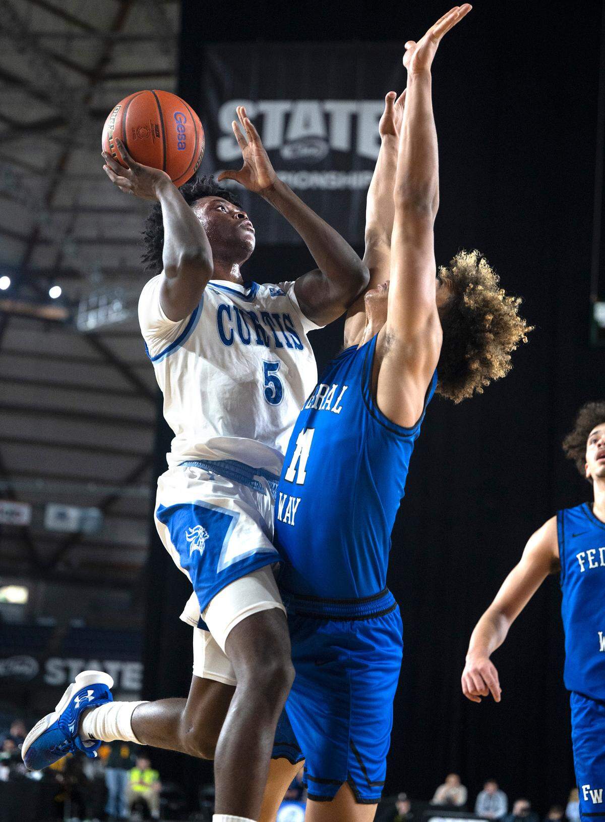 Curtis’ Zoom Diallo flies to the basket against Federal Way defender Isaiah Afework during their state semifinal game at the WIAA state basketball tournament in the Tacoma Dome in Tacoma, Washington, on Friday, March 3, 2023. Curtis won the game, 56-43.