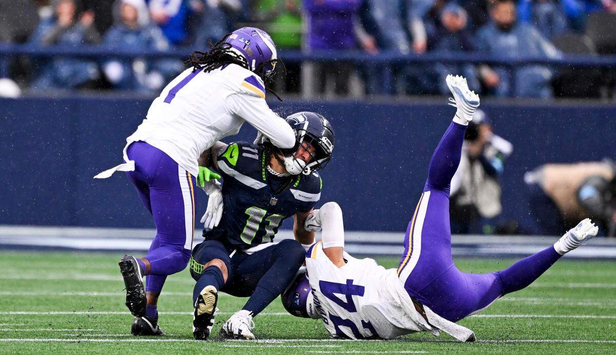 Minnesota Vikings cornerback Shaquill Griffin (1) and cornerback Fabian Moreau (23) hit Seattle Seahawks wide receiver Jaxon Smith-Njigba (11) during the first quarter of the first quarter of the game at Lumen Field, on Sunday, Dec. 22, 2024, in Seattle, Wash.