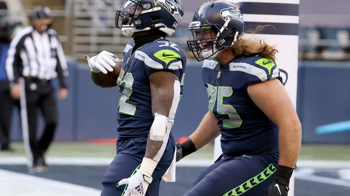 Now-former Seahawks offensive lineman Chad Wheeler (75) celebrates a touchdown run by Chris Carson (32) during Seattle’s home win over the New York Jets at Lumen Field on Dec. 13.
