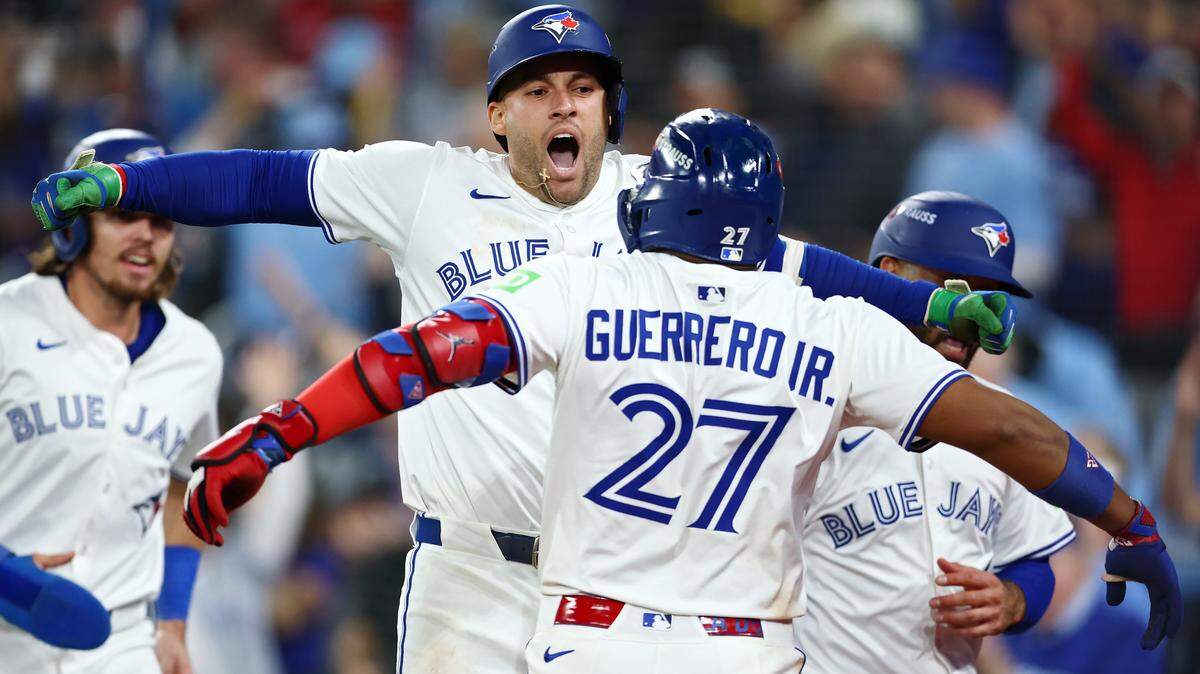 TORONTO, ONTARIO - OCTOBER 20: George Springer #4 of the Toronto Blue Jays celebrates with Vladimir Guerrero Jr. #27 after hitting a three-run home run against the Seattle Mariners during the seventh inning in game seven of the American League Championship Series at the Rogers Centre on October 20, 2025 in Toronto, Ontario. (Photo by Vaughn Ridley/Getty Images)
