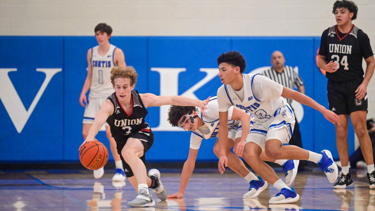 Curtis \ Union guard Bryson Metz (3) attempts to keep his dribble as he is guarded by Curtis forward Trent Williams (20) and guard Cinque Maxwell (12) during the third quarter of a District 3/4 4A semifinal game on Friday, Feb. 17, 2022, at Curtis High School in University Place, Wash.