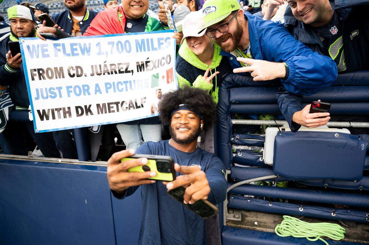 Seattle Seahawks linebacker Ernest Jones IV (13) takes a selfie with fans before the game against the Buffalo Bills at Lumen Field, on Sunday, Oct. 27, 2024 in Seattle, Wash.