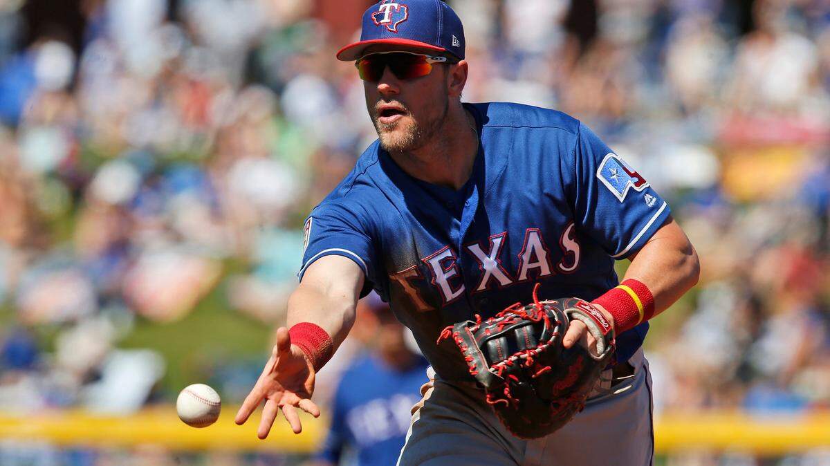 Texas Rangers first baseman Patrick Wisdom tosses the ball to pitcher Zach McAllister for a ground-out against Chicago Cubs’ Jason Heyward in the second inning of a spring training baseball game Friday, March 22, 2019, in Mesa, Ariz.