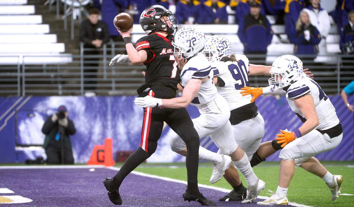 Camas quarterback Jake Davidson gets off a pass under intense pressure from the Sumner Spartans defense during Saturday’s WIAA 4A state football championship game at Husky Stadium in Seattle, Washington, on Dec. 7, 2024. Davidson was named The News Tribune’s All-State Football Player of the Year.