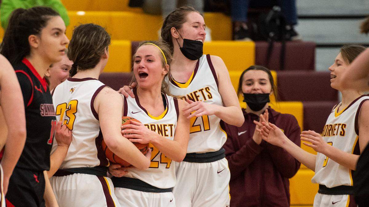 White River Hornet’s guard Josie Jacobs (24), White River Hornet’s forward Ally Green (23) and White River Hornet’s forward Ava Bright (21) celebrate after winning the high school girls basketball state tournament regional round game at Mount Tahoma High School in Tacoma, Wash. on Friday, Feb. 25, 2022.