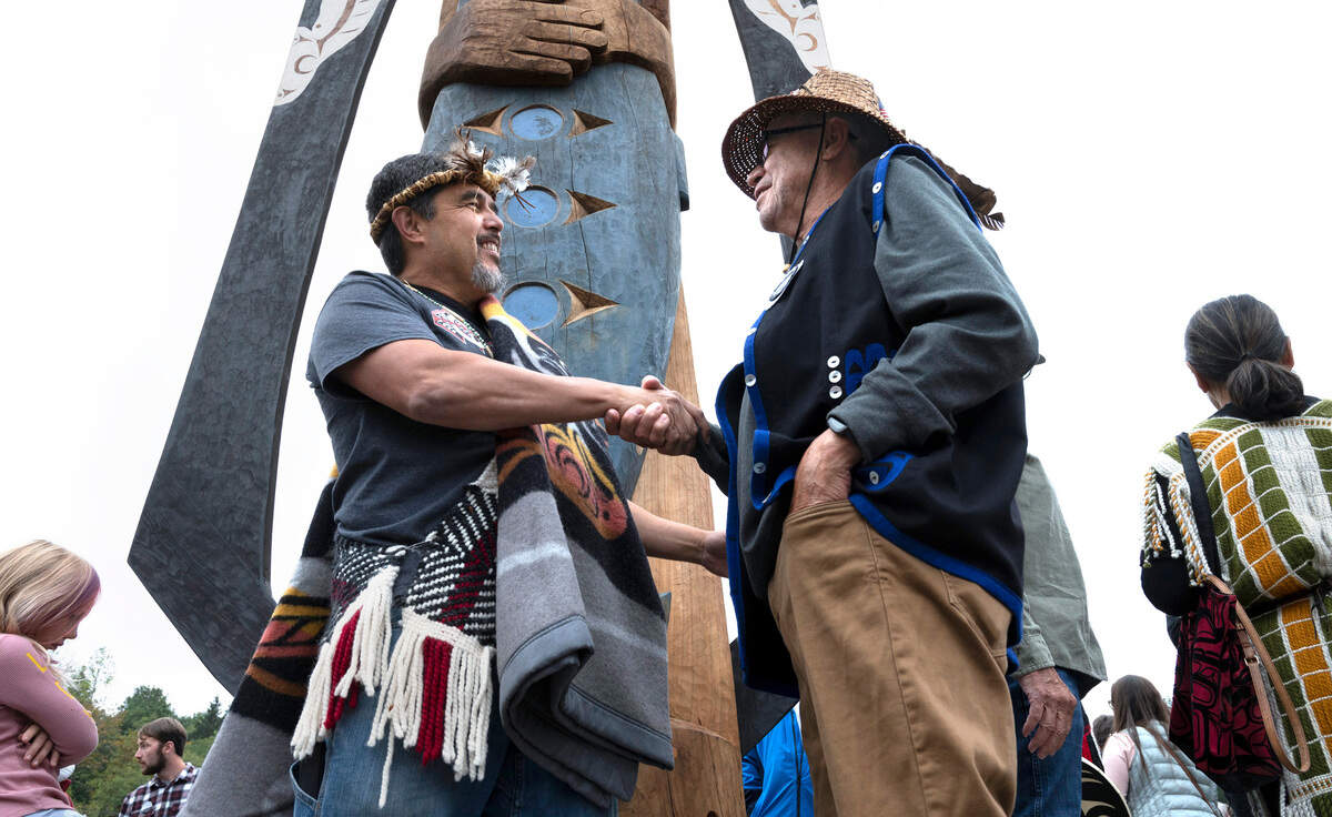 Tribal artist Guy Capoeman - who carved the “Our Fisherman, Our Guardian” statue - is thanked by Cowlitz tribal member Bill Iyall Our Fisherman, Our Guardian” carved cedar at Austin Park at txʷaalqəł Estuary on the waterfront in Gig Harbor, Washington, on Thursday, Sept. 15, 2022.