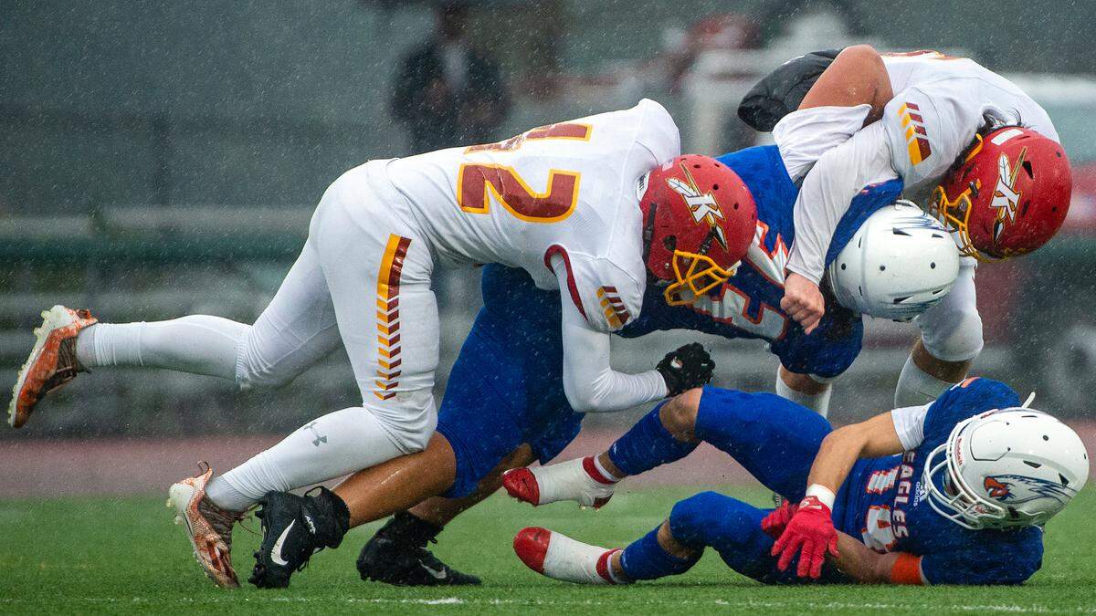 Kamiakin’s Payton Graham (right) and Walker Fabbri (left) take down Graham Kapowsin running back Michael Toa during the fourth quarter of a State 4A semifinal game on Saturday afternoon at Art Crate Field in Spanaway.