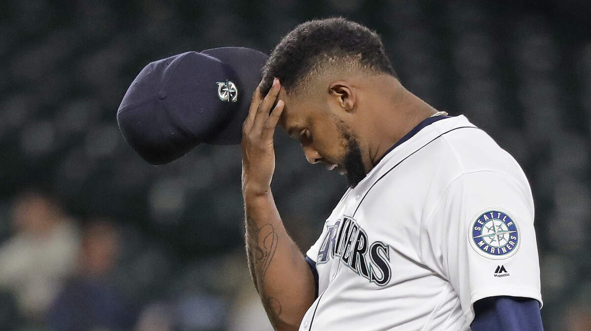 Seattle Mariners relief pitcher Juan Nicasio rubs his head after giving up a two-run home run to the Oakland Athletics during the eighth inning of a baseball game Wednesday, May 2, 2018, in Seattle. (AP Photo/Elaine Thompson)