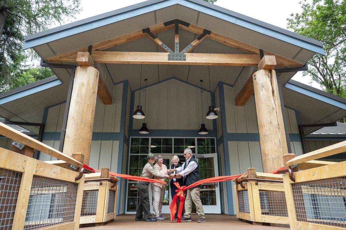 A ribbon cutting takes place for the renovated Kopachuck State Park on Friday, Aug. 1, 2025, near Gig Harbor, Wash. Olyvia Buday, from left, South Sound area manager with Washington State Parks, Diana Dupuis, director of the Washington State Parks and Recreation Commission, Pat Lantz, former commissioner with Washington State Parks and Recreation, and Scott Merriman, current commissioner with Washington State Parks and Recreation cut the ribbon in front of the new event space at the park.
