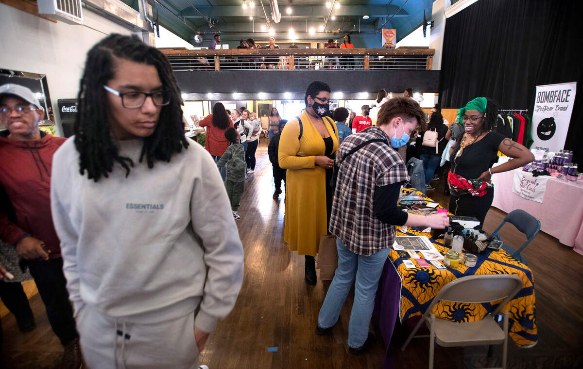 Guests browse the merchandise tables during the Black Night Market at Edison Square in Tacoma, Washington, on Friday, April 29, 2022.