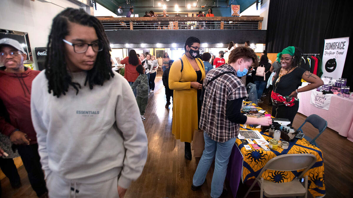 Guests browse the merchandise tables during the Black Night Market at Edison Square in Tacoma on April 29, 2022. A holiday version of the popular market will be held Nov. 30.