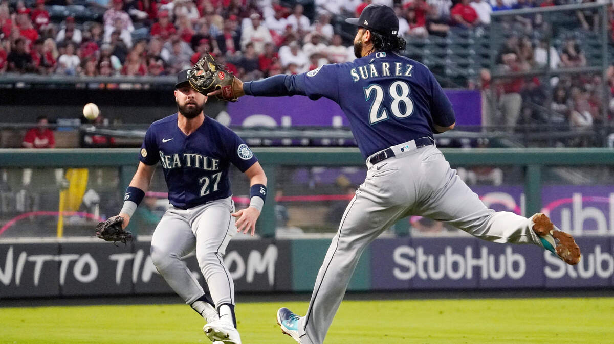Seattle Mariners third baseman Eugenio Suarez, right, can’t get to a ball hit for a double by Los Angeles Angels’ Shohei Ohtani as left fielder Jesse Winker watches during the first inning of a baseball game Friday, Sept. 16, 2022, in Anaheim, Calif. (AP Photo/Mark J. Terrill)