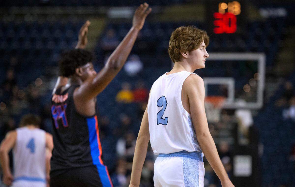 Gig Harbor’s Ryan Pickles walks off the court as Rainier Beach’s Josh Conerly Jr. celebrates during Thursday afternoon’s quarterfinal game of the WIAA 3A Boys Basketball State Championships tournament in the Tacoma Dome in Tacoma, Washington, on Thursday, March 3, 2022. Rainier Beach won the game, 65-60.