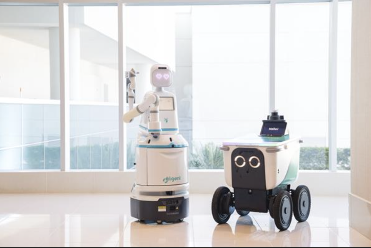 A photo accompany the release of the recent acquisition of Diligent Robotics, maker of Moxi, by Serve Robotics, maker of sidewalk delivery robots.