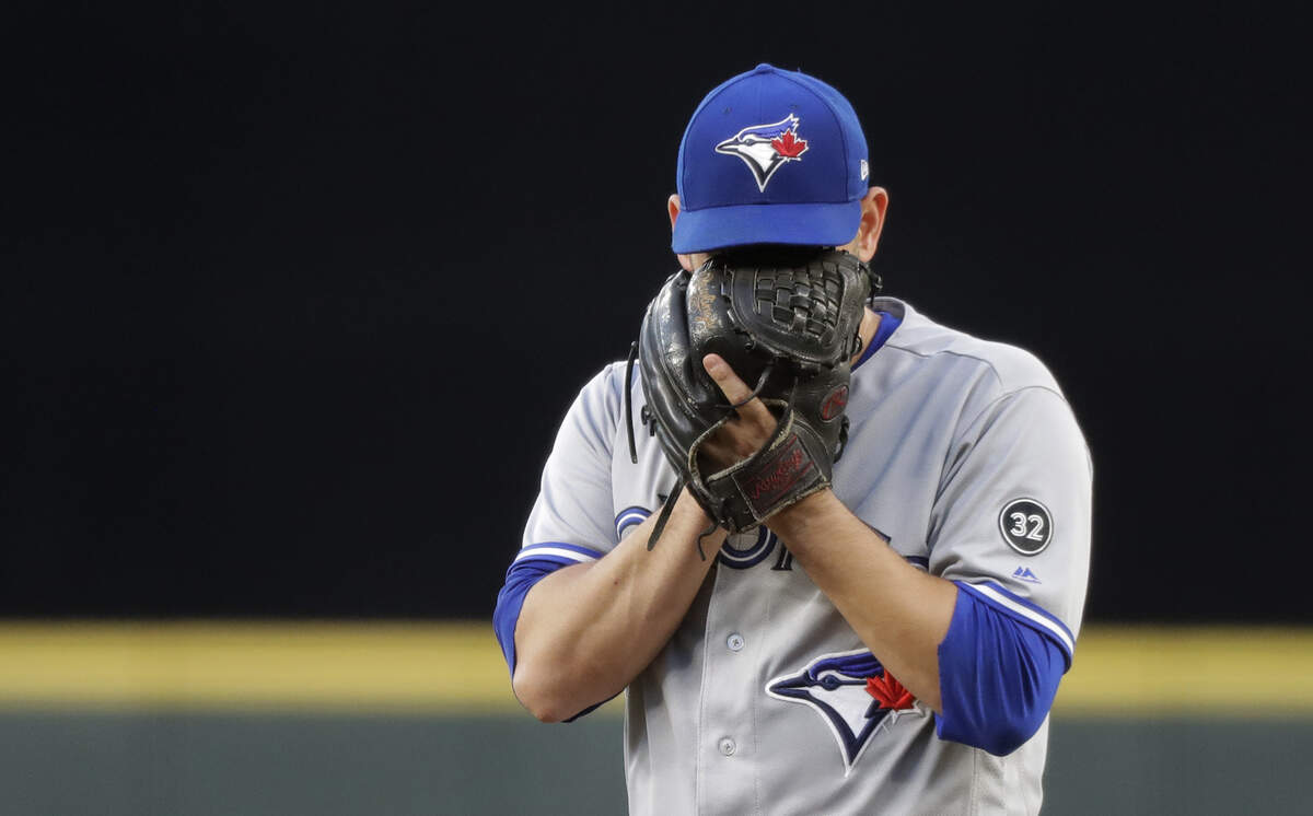 Toronto Blue Jays starting pitcher Marco Estrada covers his face with his glove as he stands on the mound during the fourth inning of the team’s baseball game against the Seattle Mariners, Saturday, Aug. 4, 2018, in Seattle. (AP Photo/Ted S. Warren)
