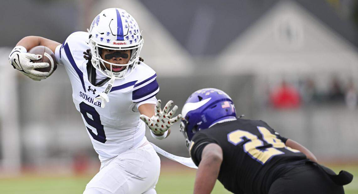Sumner running back Lance McGee (9) makes Puyallup cornerback Markel Newell (24) miss during the first half of the 4A state semifinal game at Sparks Stadium, on Saturday, Nov. 29, 2025 in Puyallup, Wash.