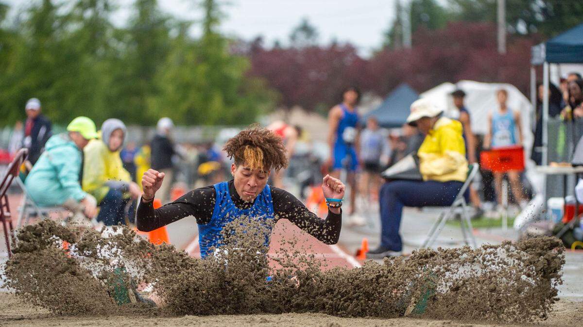 Sand flies in the air as Federal Way’s Roman Hutchinson lands in the pit after a triple-jump attempt at the State 2A, 3A, 4A track and field championships on Thursday, May 26, 2022, at Mount Tahoma High School in Tacoma Wash.