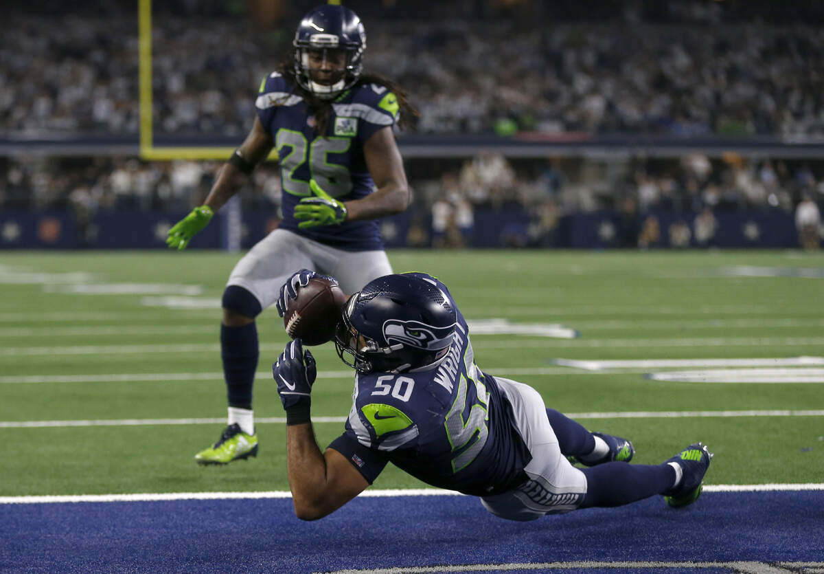 Dallas Cowboys wide receiver Noah Brown (85) has a pass thrown to him intercepted by Seattle Seahawks linebacker K.J. Wright (50) during an NFC wild-card NFL football game in Arlington, Texas, Saturday, Jan. 5, 2019.(AP Photo/Ron Jenkins)