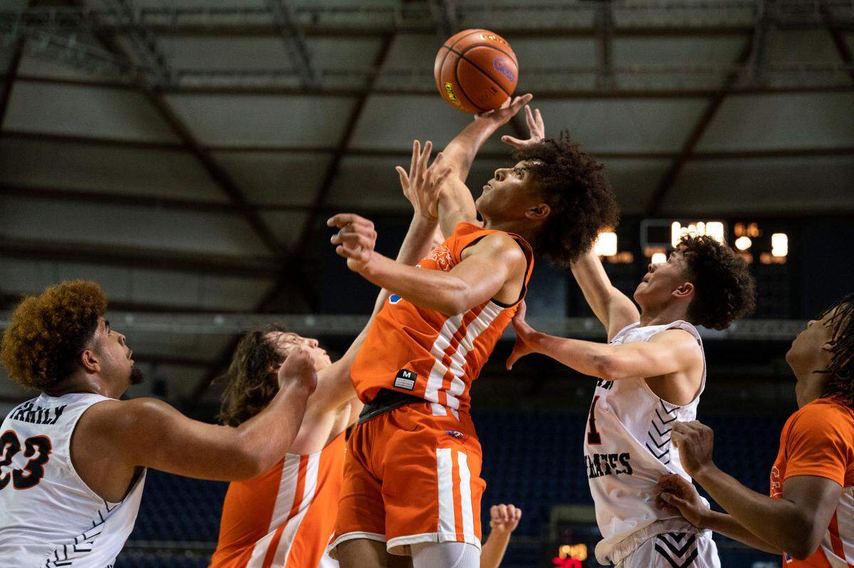 Graham-Kapowsin’s Joshua Wood (center) attempts to collect an offensive rebound as Davis guard Brandon Lee Jr. (1) and forward Dhantaye Bennett-Joe (23) vie to the ball as well during the first quarter of a Class 4A state tournament game on Wednesday, March 2, 2022, at the Tacoma Dome, in Tacoma, Wash.