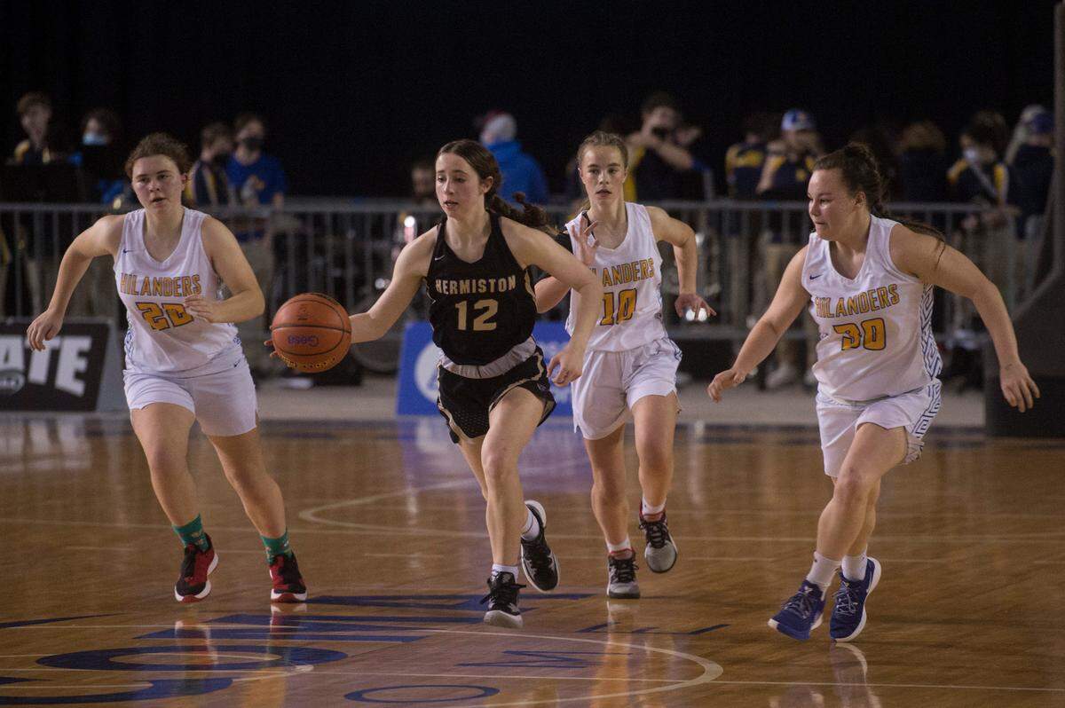 Hermiston High School guard Izzy Simmons (12) brings the ball up the floor surrounded by Kelso defenders. Hermiston beat Kelso, 57-46, in a Class 3A state basketball first round game on Wednesday, March 2, 2022 at the Tacoma Dome in Tacoma, Wash.