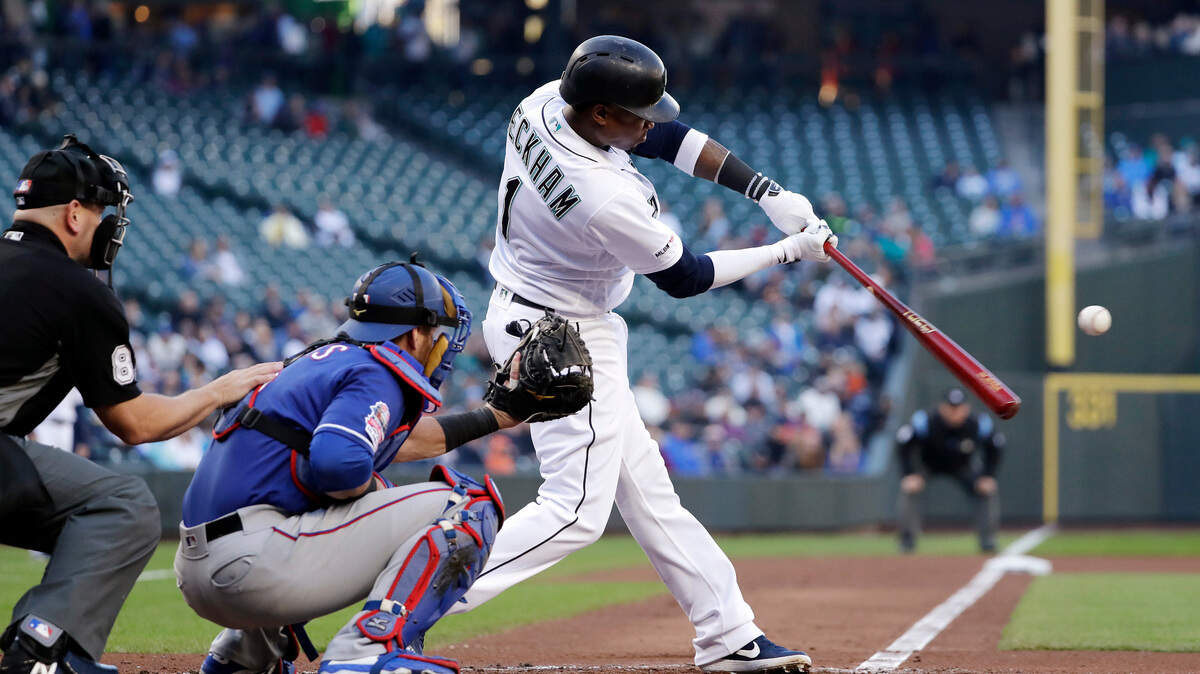 Seattle Mariners’ Tim Beckham, right, swings and misses to strike out as Texas Rangers catcher Jeff Mathis, second from left, looks on in the first inning of a baseball game Saturday, April 27, 2019, in Seattle.