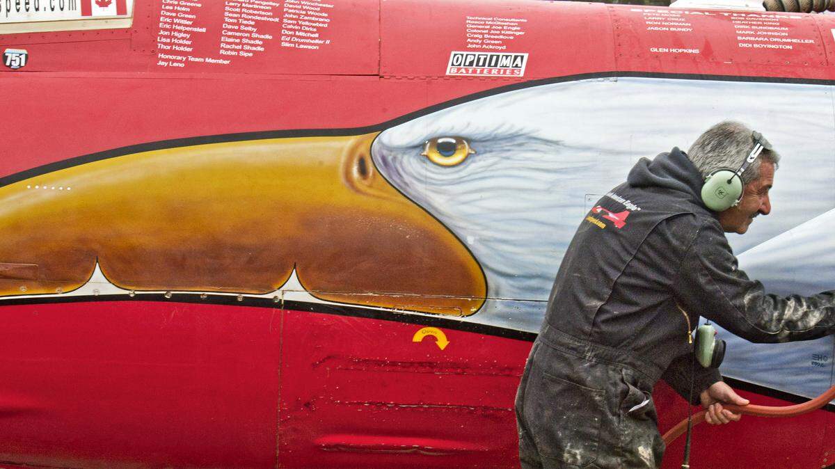Les Holm sprays in an intake of North American Eagle, a jet car, during a cleaning operation Oct. 19, 2013, after a recent test run on a dry lake bed in eastern Oregon. The vehicle is a fighter jet that has been converted to a car intended to break the land speed record.
