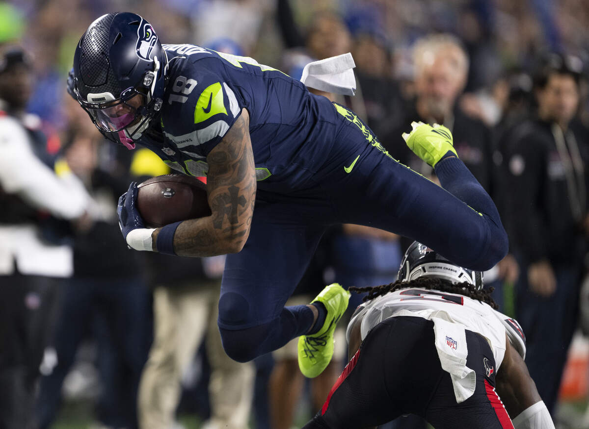 Seattle Seahawks tight end Elijah Arroyo (18) gets airborne over Houston Texans safety Calen Bullock (2) on a 27-yard reception during the first quarter of the game at Lumen Field, on Monday, Oct. 20, 2025, in Seattle.