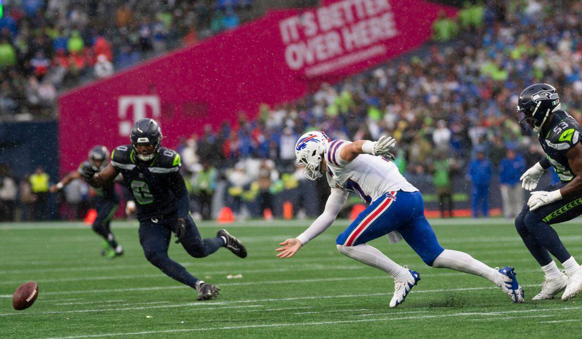 Buffalo Bills quarterback Josh Allen (17) and Seattle Seahawks linebacker Tyrel Dodson (0) run after a loose ball during the second quarter of the game at Lumen Field, on Sunday, Oct. 27, 2024 in Seattle, Wash.