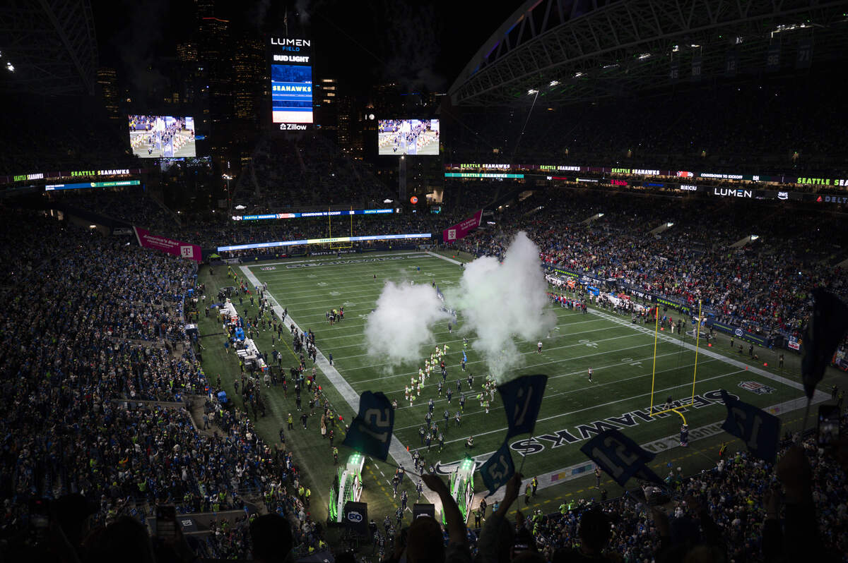 Fans wave 12 flags as players run out before the game between the Seattle Seahawks and the Houston Texans at Lumen Field, on Monday, Oct. 20, 2025, in Seattle.