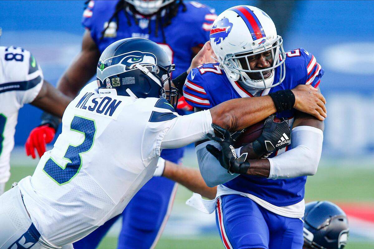 Buffalo Bills’ Tre’Davious White (27) runs back an interception as Seattle Seahawks quarterback Russell Wilson (3) attempts to tackle him during the second half of an NFL football game Sunday, Nov. 8, 2020, in Orchard Park, N.Y. (AP Photo/John Munson)