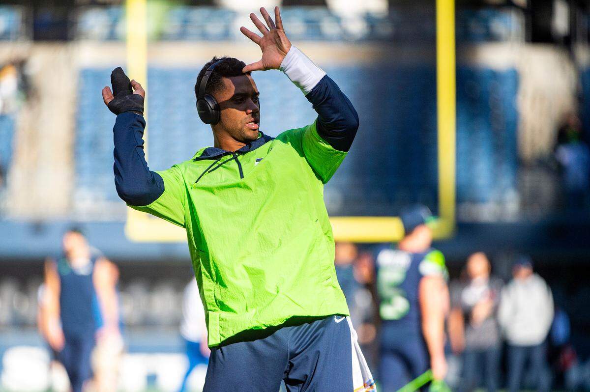 With a new wrap on his fingers, Seahawks quarterback Russell Wilson goes through the motions of throwing passes and running the offense prior to the start of Seattle’s game against Jacksonville on Sunday at Lumen Field in Seattle.