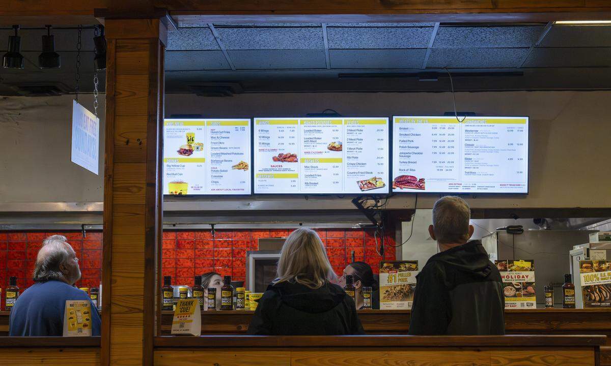 Customers look up at the menu before ordering at Dickey's Barbecue Pit on Thursday, Nov. 13, 2025, in Puyallup, Wash.