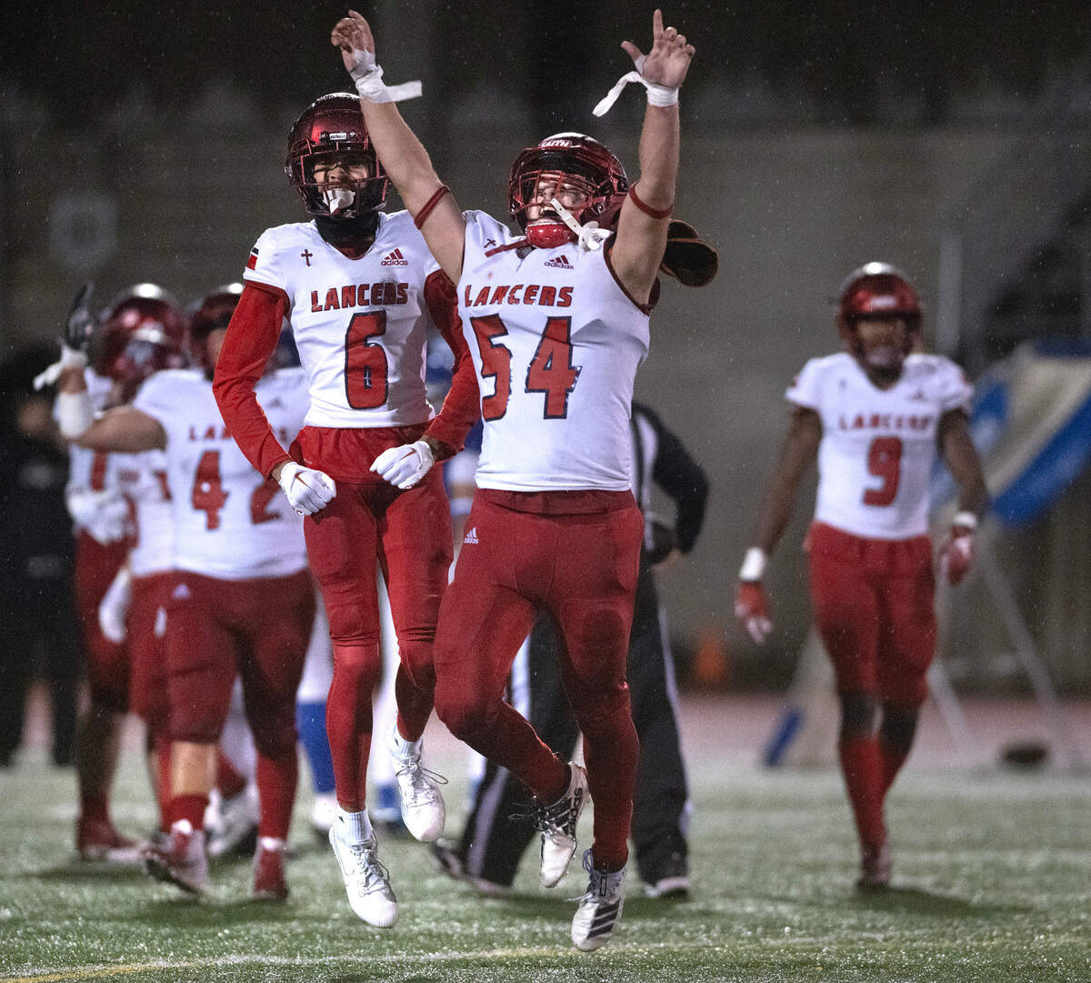 Kennedy Catholic’s Joey Thomas III (left) and senior linebacker Thomas Bevilacqua celebrate as time expires in the Lancers’ 37-34 victory over the Curtis Vikings in Friday night’s 4A state football opening round game at Viking Stadium in University Place, Washington, on Nov. 10, 2023.