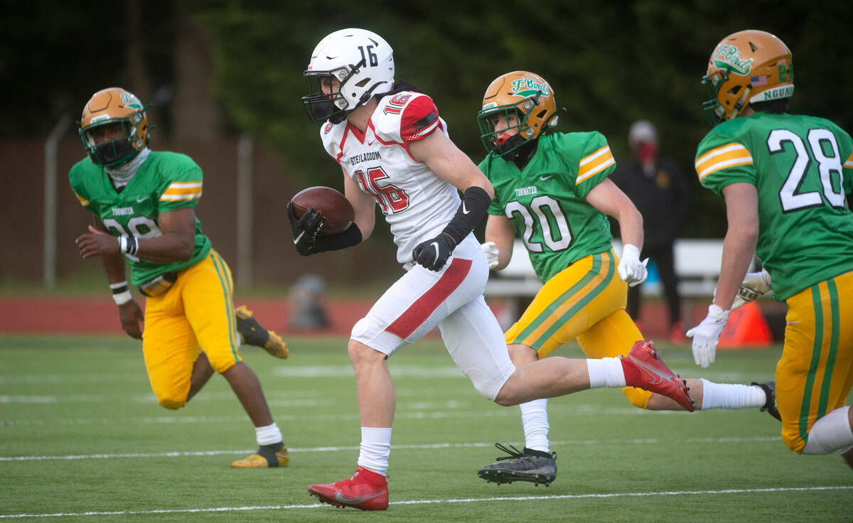 Steilacoom wide receiver Cole Miller races away from Tumwater defensive back Turner Allen (from left), Jack Jones and Ryan Orr during Saturday night’s high school football game at Tumwater District Stadium on Saturday, March 20, 2021.