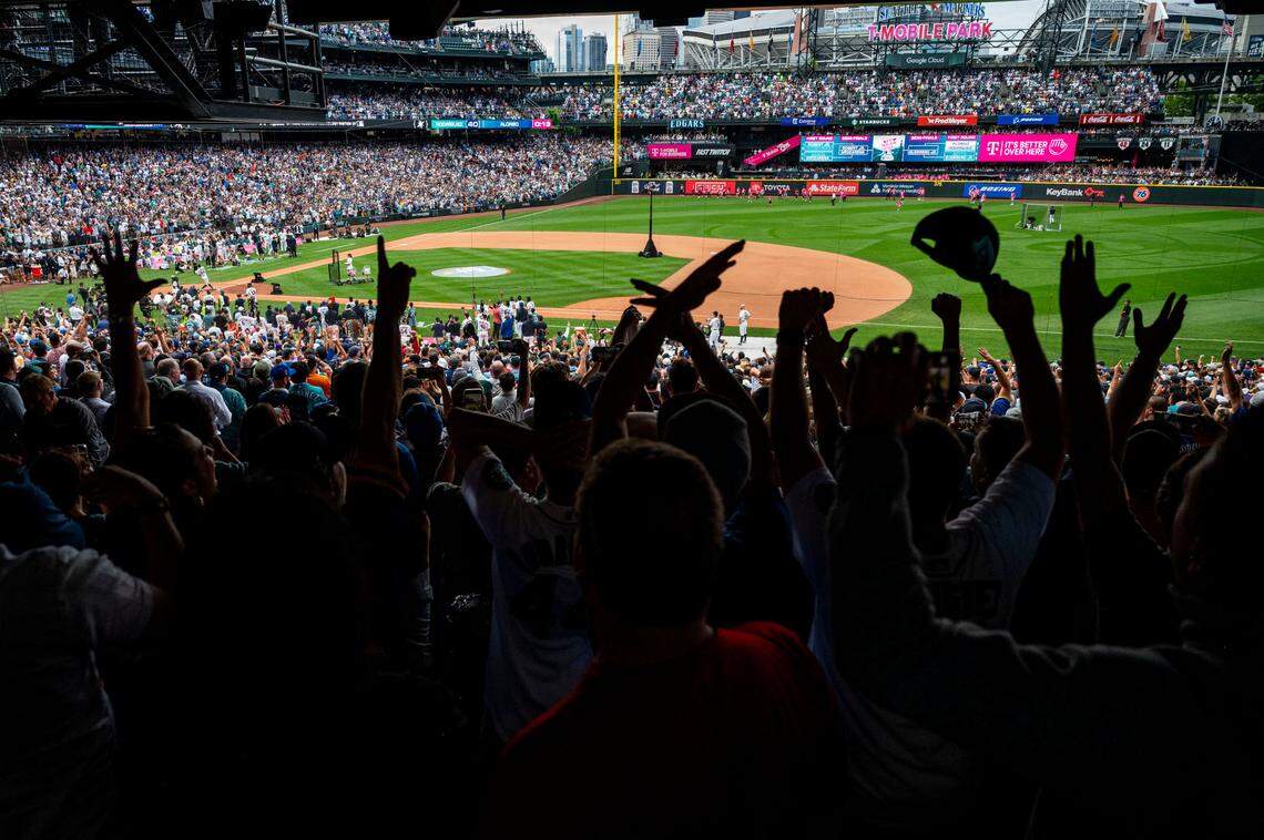 Fans raises their hands in celebration as Mariners All-Star Julio Rodriguez hits his 40th home run of the first round of the 2023 MLB Home Run Derby on Monday, July 10, 2023, at T-Mobile Park in Seattle.