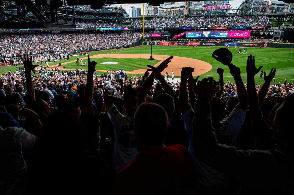 Fans raises their hands in celebration as Mariners All-Star Julio Rodriguez hits his 40th home run of the first round of the 2023 MLB Home Run Derby on Monday, July 10, 2023, at T-Mobile Park in Seattle.