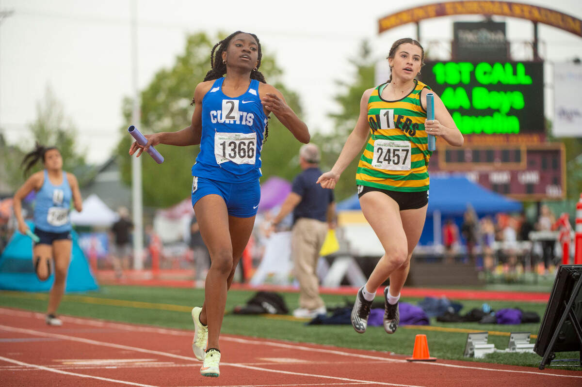 Curtis’ Ava Simms crosses the finish line just ahead of Richland’s Emma Wahlstrom in a heat of the 4A 4x200 relay at the State 2A, 3A, 4A track and field championships on Thursday, May 26, 2022, at Mount Tahoma High School in Tacoma Wash.